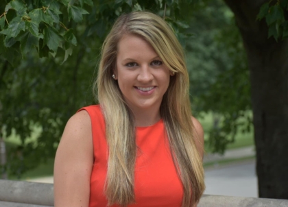 Woman with long blonde hair and a red/orange top