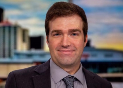 Man with short brown hair in a suit and tie