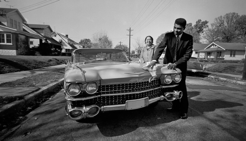 Muhammad Ali cleans a car as his mother looks on