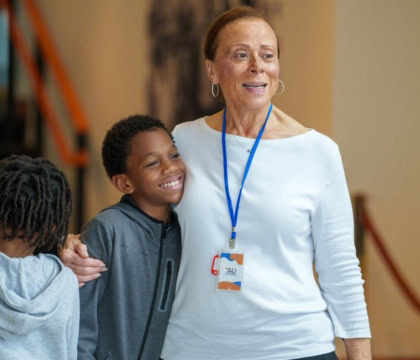 Photo of Lonnie Ali posing with young man with both smiling off camera